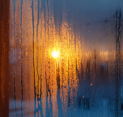 Wall Mural - A window with condensation on it and a sun shining through