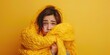 © vefimov - Woman is wrapped in a yellow blanket and appears to be cold. She is looking down and she is sad