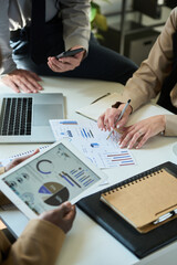 Aufkleber - Cropped shot of three unrecognizable brokers analyzing financial charts and diagrams at working meeting in office