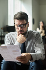 Aufkleber - Young businessman thinking of market development while looking through financial data in paper document