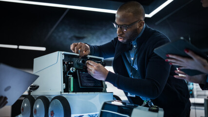 Fototapete - Portrait of an African Engineer Using a Screwdriver While Developing a Remotely Controlled Delivery Robot. Black Specialist Working in High Tech Research Laboratory with Modern Equipment