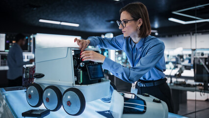 Fototapete - Portrait of a Female Technical Specialist Working in High Tech Research Laboratory with Modern Equipment: Female Adjusting Equipment on a Delivery Robot 