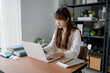© Charlie's - Asian woman working with laptop in living room