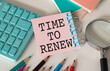 © Pawel - Time to Renew. text on white paper on white background near calculator, pencil, colored pencils