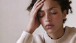 © Karen - Woman holding head in pain indoors
