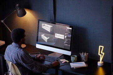 Leinwandbilder - Man using computer software for designing furniture models while sitting at desk in modern office setting with comfortable atmosphere