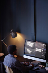 Leinwandbilder - Person sitting at desk while using computer with design software displaying couch models. Lamp providing illumination and creating cozy atmosphere in minimalistic office setting