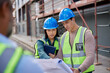 © Rido - Construction workers discussing blueprint at building site