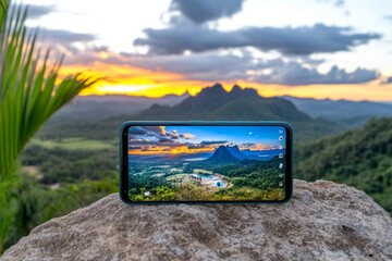 Aufkleber - A close-up image of a sleek smartphone capturing a stunning sunset, with the photo displayed on its screen