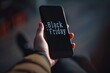 © AHNH5 - Close-Up of Hand Holding Phone with Black Friday Text on Screen, Ideal for Promotions and Sales Marketing Imagery in Modern Retail Settings