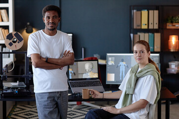 Fototapete - Two colleagues collaborating in modern tech office with multiple devices and gadgets on desks, focused on virtual project displayed on screens