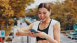 © Daniels C/peopleimages.com - Woman, laughing and phone of fitness in city, communication and sports application. Happy, female athlete and typing on mobile with social media, funny blog and contact for travel directions in Japan
