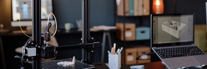 Fototapete - 3D printer in a technologically advanced workspace creating an intricate object. Background with open laptop, pencil holder, and shelves filled with organized items