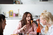 © Alessandro Grandini - Happy friends laughing and eating spaghetti during a dinner party at home