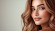 © Katarina - A portrait of an elegant woman with natural makeup and wavy hair, capturing a warm smile and a sophisticated, stylish look against a neutral background.