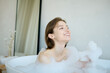 © AnnaStills - Medium close up of Caucasian woman playing with foam while taking hot and relaxing hot bathtub at home