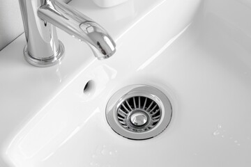 Poster - A bathroom sink with a drain and a faucet, ideal for interior design, architecture, or lifestyle photography projects