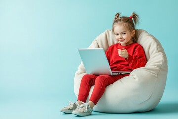 Poster - A young girl sits comfortably on a bean bag chair, focused on her laptop
