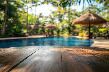 Poster - A serene poolside view with wooden table and lush greenery.