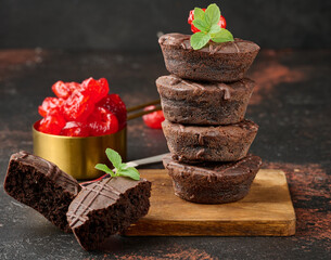 Wall Mural - Chocolate brownies stacked, with the top adorned by a juicy red cherry and mint leaves