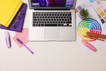 Poster - Designer's workplace with laptop, stationery and palettes on white table, flat lay. Space for text