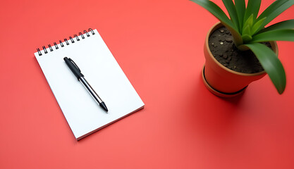 Aufkleber - A small pen, a spiral notebook, and a flowerpot sit on a bright red background with empty space surrounding them._00001_