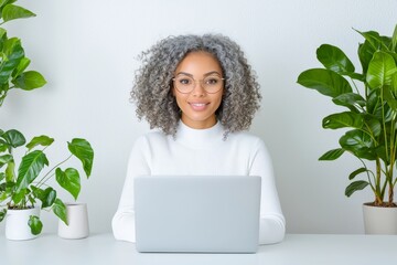 Poster - A busy, middle-aged businesswoman participates in a hybrid meeting at her office. A senior, mature female leader and HR manager engages in a conference call and conducts a remote online job interview