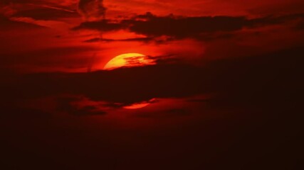 apocalyptic cinematic big sun disk sun set behind dark dirty clouds timelapse. dazzling hot sunset s