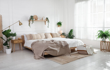 Poster - Stylish bedroom interior with large bed, houseplants and decorative elements