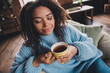 © deagreez - Young woman enjoying a warm cup of tea at home during a cozy autumn afternoon