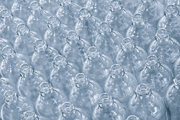 Poster - Glass bottles line on a conveyor belt. Bottles are transparent and clean.