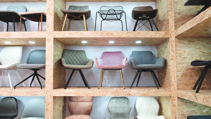 Poster - A row of wooden shelves with a variety of chairs on them. The chairs are of different colors and styles