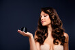 © Beauty Hero - Elegant woman with brunette hair holding beauty product against dark grey background