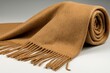 © Natchanok - Soft Brown Cashmere Scarf with Fringes Draped on a Grey Surface