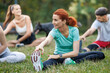 © ivanko80 - Group Outdoor Stretching Class in a Sunny Park Setting