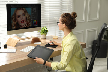 Fototapete - Professional retoucher working on graphic tablet at desk in office