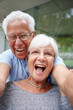 © peopleimages.com - Laughing, selfie and smile with senior couple outdoor in garden of home together for memories or romance. Funny, love and portrait of mature man with woman in neighborhood for photograph or picture