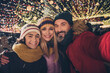 © deagreez - Photo of three lovely positive people make selfie hug spend festive midnight bazaar lights outdoors
