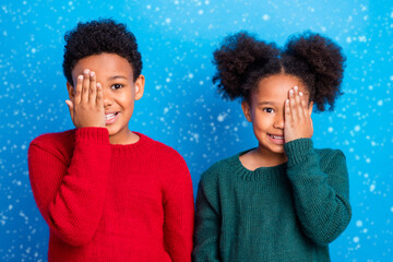 Wall Mural - Photo of childish fooling dark skin kids dressed sweaters arms close eyes smiling isolated blue color background