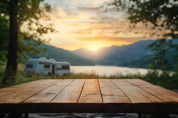 Wall Mural - A serene sunset view over a lake with a table in the foreground and a camper in the background.