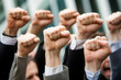 © The Stock Photo Girl - A group of people raising their fists in solidarity or protest.