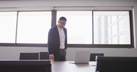Poster - Asian businessman at the office of a creative business, using a laptop computer