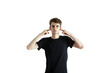 © peshkova - Young man covering ears with fingers, wearing aT-shirt, on an isolated white background. Concept of ignoring, blocking, or refusal
