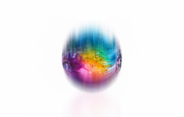 Poster - An isolated glass egg with a rainbow swirl and air bubbles sits on a white background.
