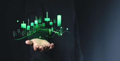 Poster - Financial candlestick chart with glowing green data in a human hand on a dark background. Concept of stock market, forex, and business analytics.