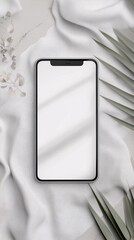 Poster - Smartphone with blank screen displaying on white satin cloth with tropical leaves