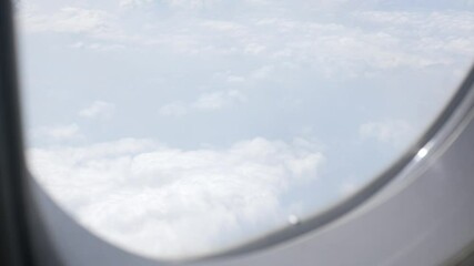 Wall Mural - Looking at the sky through an airplane window while flight flying trip travel above clear blue sky with beautiful cloud,looking at view through window of plane 