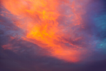 Wall Mural - a breathtaking view of the evening sky with clouds shining red-orange shades.