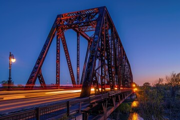 Poster - A train crosses over a bridge at night, lit up by the city lights