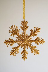 Poster - A delicate gold snowflake hangs from a golden ribbon, perfect for winter wonderland or festive decor